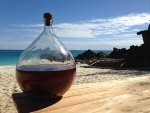 Bottle of homemade rum by the sea